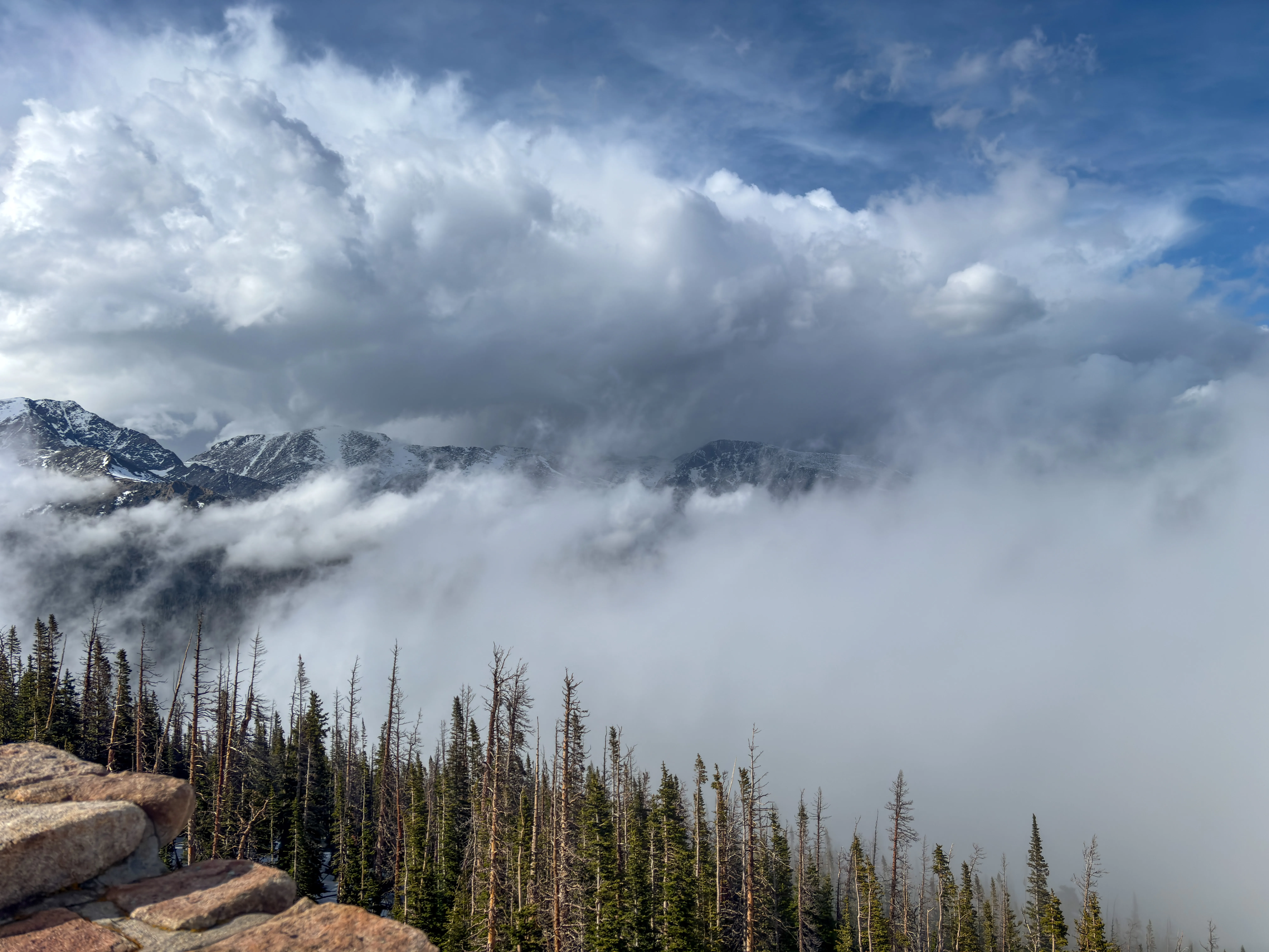 The peaks of the Rocky Mountains, obscured by clouds.